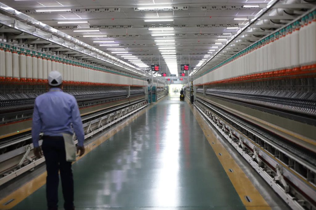 Industrial automation consultant walking through a modern, automated textile manufacturing facility to optimize production efficiency
