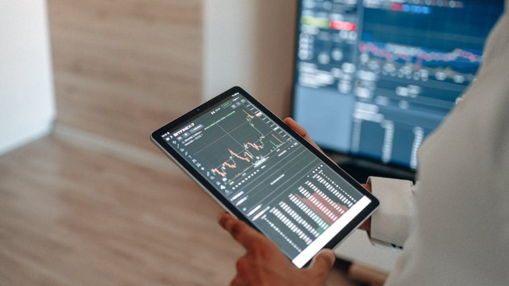 Industrial automation consultant reviewing real-time data analytics and production performance metrics on a tablet.